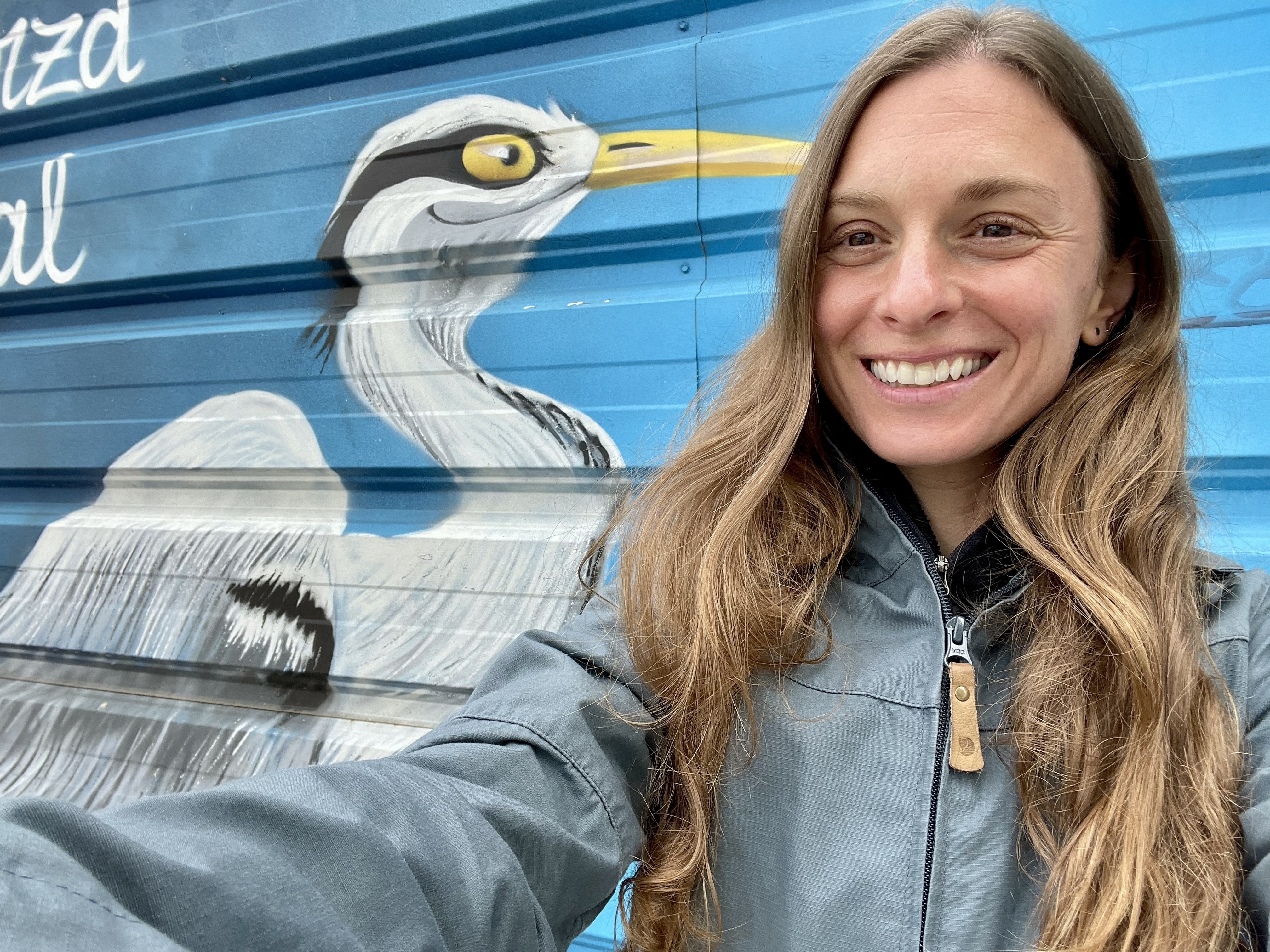 Zoë Kern smiling in front of a mural